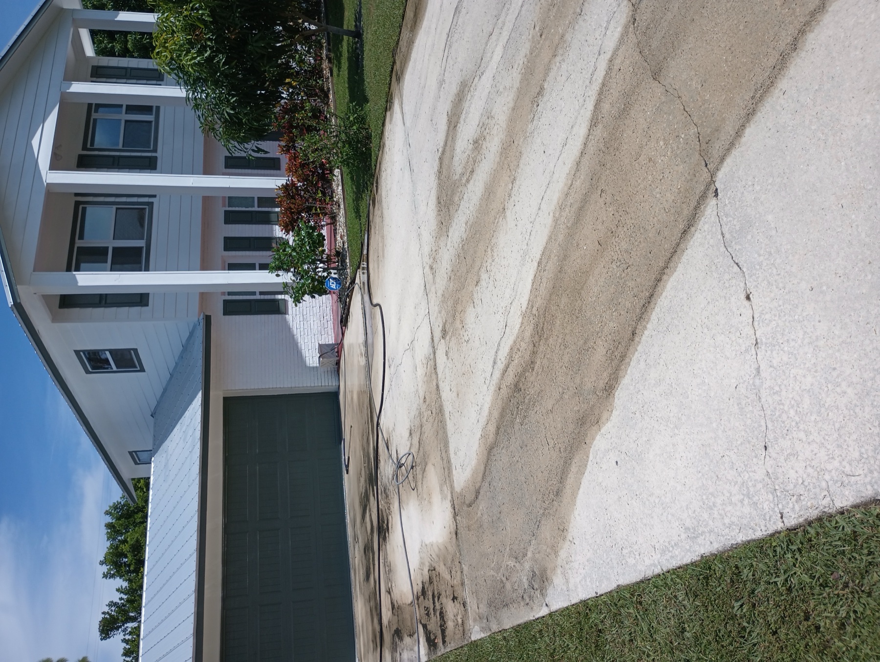 Stained concrete driveway before cleaning and coating